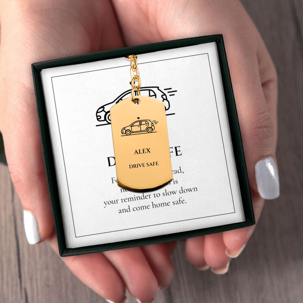 Hands holding the DRIVE SAFE name keychain gift box