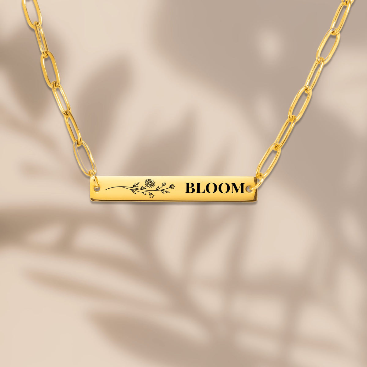 Wildflower engraved bar necklace with soft leaf shadows