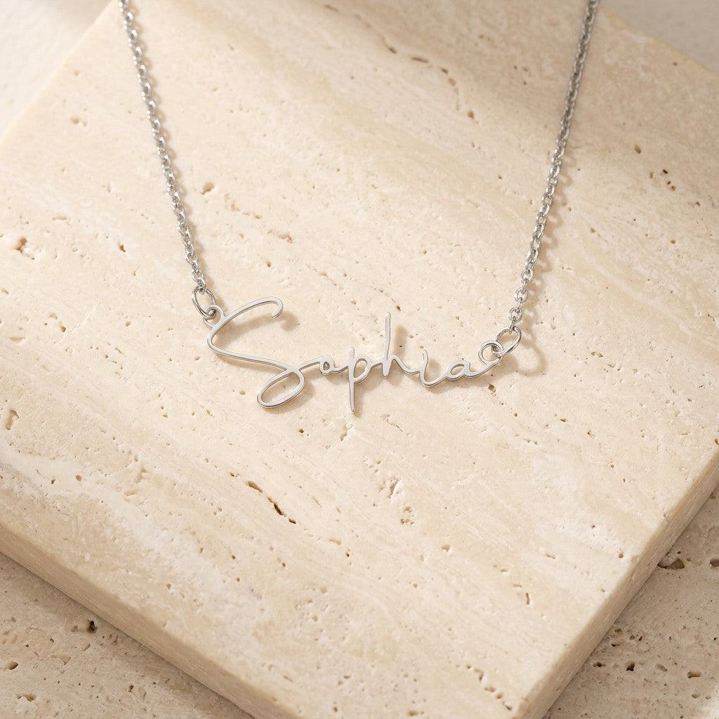 Signature name necklace in silver on cream travertine