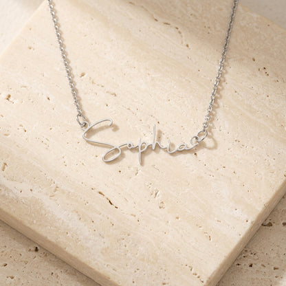 Signature name necklace in silver on cream travertine