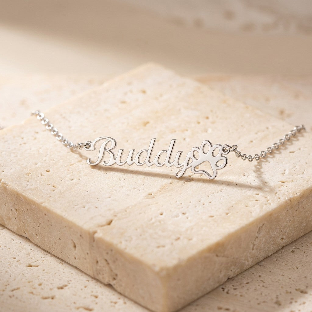 Paw print name necklace on cream travertine