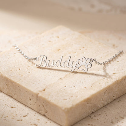 Paw print name necklace on cream travertine