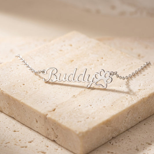 Paw print name necklace on cream travertine