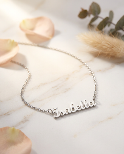 Steel name necklace reading Isabella on cream marble with flowers | Custom Name Necklace
